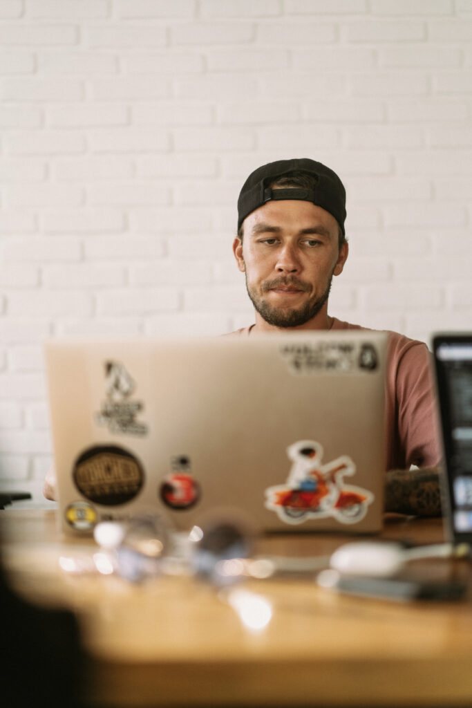 Ein Mann arbeitet an einem Laptop an seinem Business - dank einer Webseite von opticore solutions kann er sich auch darauf konzentrieren